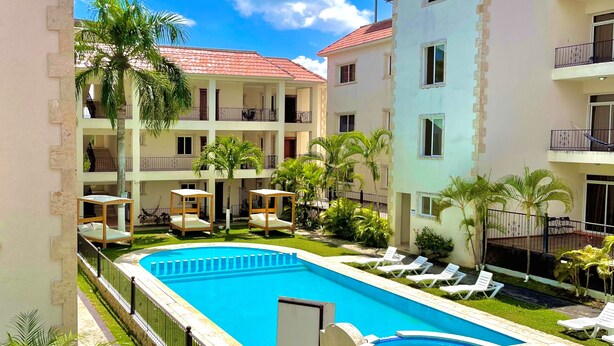 Un hôtel doté d’une piscine, de nombreux balcons et de palmiers.