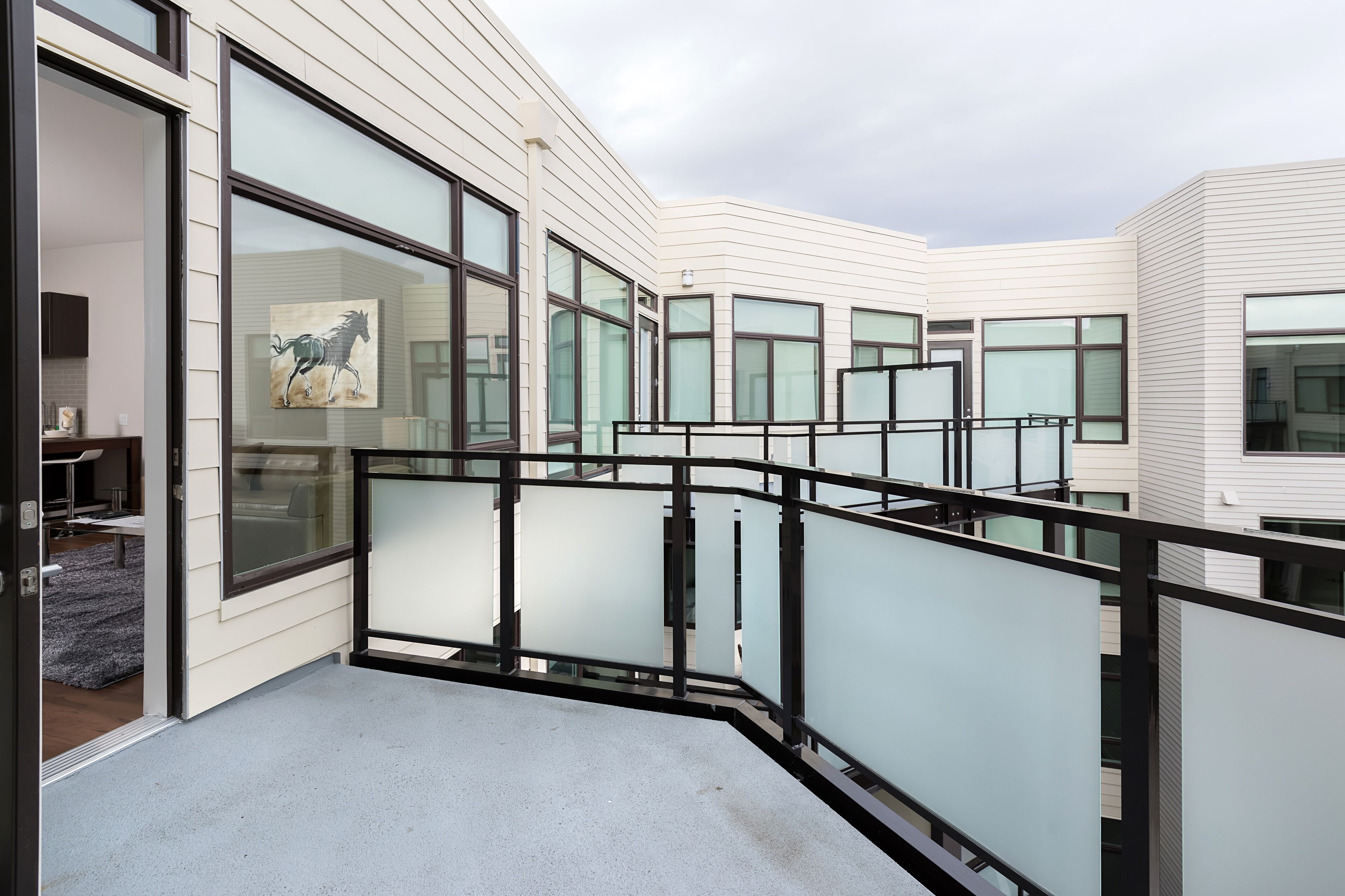 Un bâtiment moderne doté de grandes fenêtres et d’une balustrade en verre.