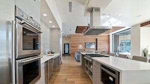 A modern kitchen with stainless steel appliances, a central island, and a view to the dining area. - Global Luxury Suites at Mountain View (Mountain View)