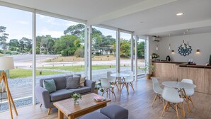 A modern interior with a sofa, coffee table, and dining area with chairs. - Live Hotel Boutique - Adults Only (Punta del Este)