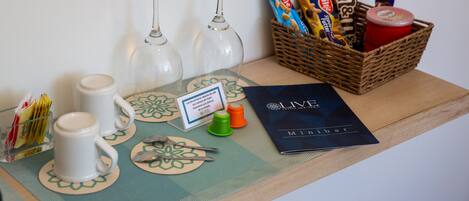 A table with two wine glasses, a basket of snacks, a menu, and a small sign.