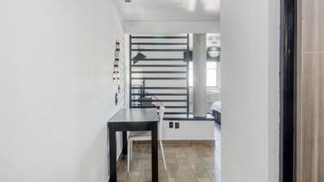 A modern kitchen with a black countertop, a white bench, and a large window with a view of the city.