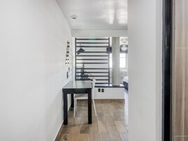 Una cocina moderna con encimera negra, banco blanco y un amplio ventanal con vistas a la ciudad.