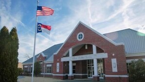 A brick building with a large arched entrance labeled "Troy Town Hall".