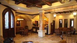 A spacious lobby with a grand staircase, a reception desk, and comfortable seating areas. - Hotel Gran Mediterraneo (San Pedro Sula)