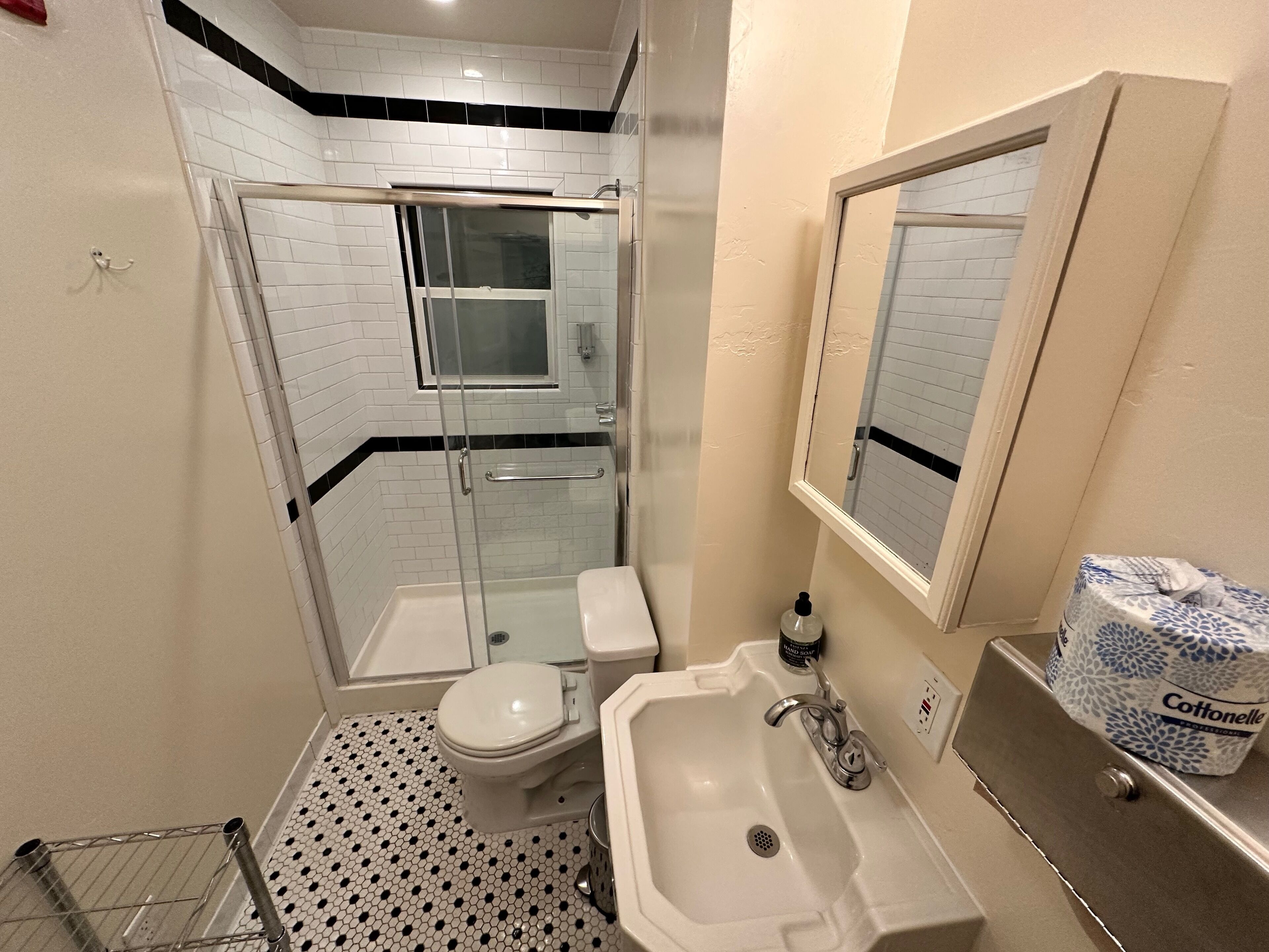 Un baño con ducha de vidrio, inodoro, lavabo y espejo.