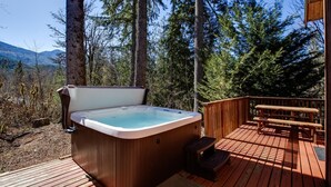 A hot tub on a wooden deck with a view of a forest and mountains. - 44mbr - Hot Tub- Pets Ok - Wifi - Bbq - Sleeps 8 2 Bedroom Home by RedAwning (Deming)