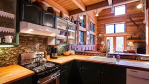 A rustic kitchen with a wooden ceiling, a stove, and a sink. - 44mbr - Hot Tub- Pets Ok - Wifi - Bbq - Sleeps 8 2 Bedroom Home by RedAwning (Deming)