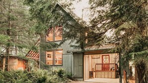 A rustic cabin with a steeply pitched roof, large windows, and a wooden porch. - 70mbr- Hot Tub - Bbq - Wi-fi - Pets Ok - Sleeps 8 3 Bedroom Home by RedAwning (Deming)