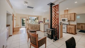 A spacious living area with a fireplace, wooden furniture, and a kitchen with modern appliances. - 70mbr- Hot Tub - Bbq - Wi-fi - Pets Ok - Sleeps 8 3 Bedroom Home by RedAwning (Deming)