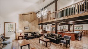 A spacious living area with a wooden staircase, leather sofas, and a dining area with wooden chairs. - 03mbh -12-bdrm - 3.5-bath - Wifi - Pets Ok - Sleeps 26 12 Bedroom Home by RedAwning (Deming)