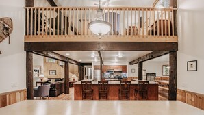 A spacious dining area with a high ceiling and wooden beams, a kitchen with modern appliances, and a cozy seating area with a fireplace. - 03mbh -12-bdrm - 3.5-bath - Wifi - Pets Ok - Sleeps 26 12 Bedroom Home by RedAwning (Deming)