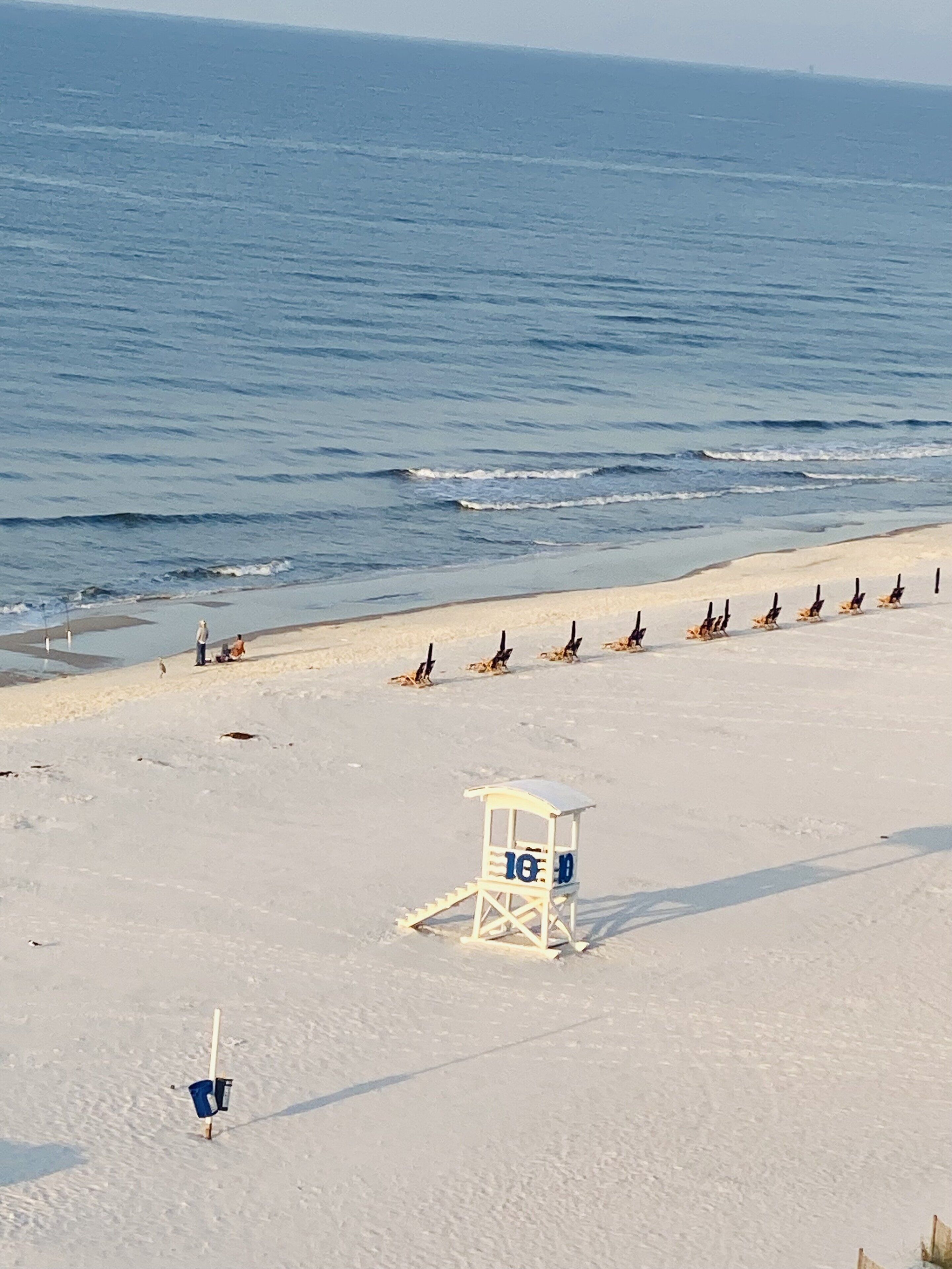 A beach with lifeguard towers, a sandy shore, and the ocean in the background.