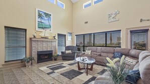 Un salon spacieux avec une cheminée, un grand canapé et une table basse.