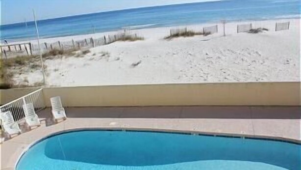 A swimming pool with a view of the beach and ocean.