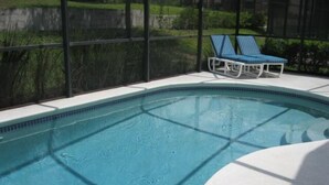 A swimming pool with two lounge chairs. - Beautiful Vacation Home fully equipped (Haines City)