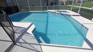 Une piscine aux eaux cristallines, dotée d’une terrasse blanche et d’un espace abrité.