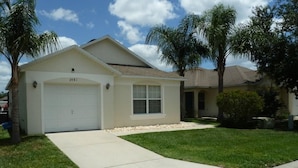 A single-story house with a garage, a well-maintained lawn, and a clear sky. - Very Comfortable Villa Fully Equipped (Haines City)