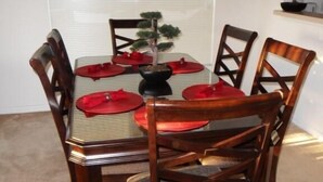A dining table with six chairs, a small potted plant, and a hanging light fixture. - Amazing Villa at an Exceptional Price (Haines City)