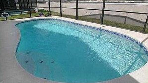 A swimming pool with a tiled edge and a metal fence surrounding it. - Very Comfortable Villa Fully Equipped (Haines City)