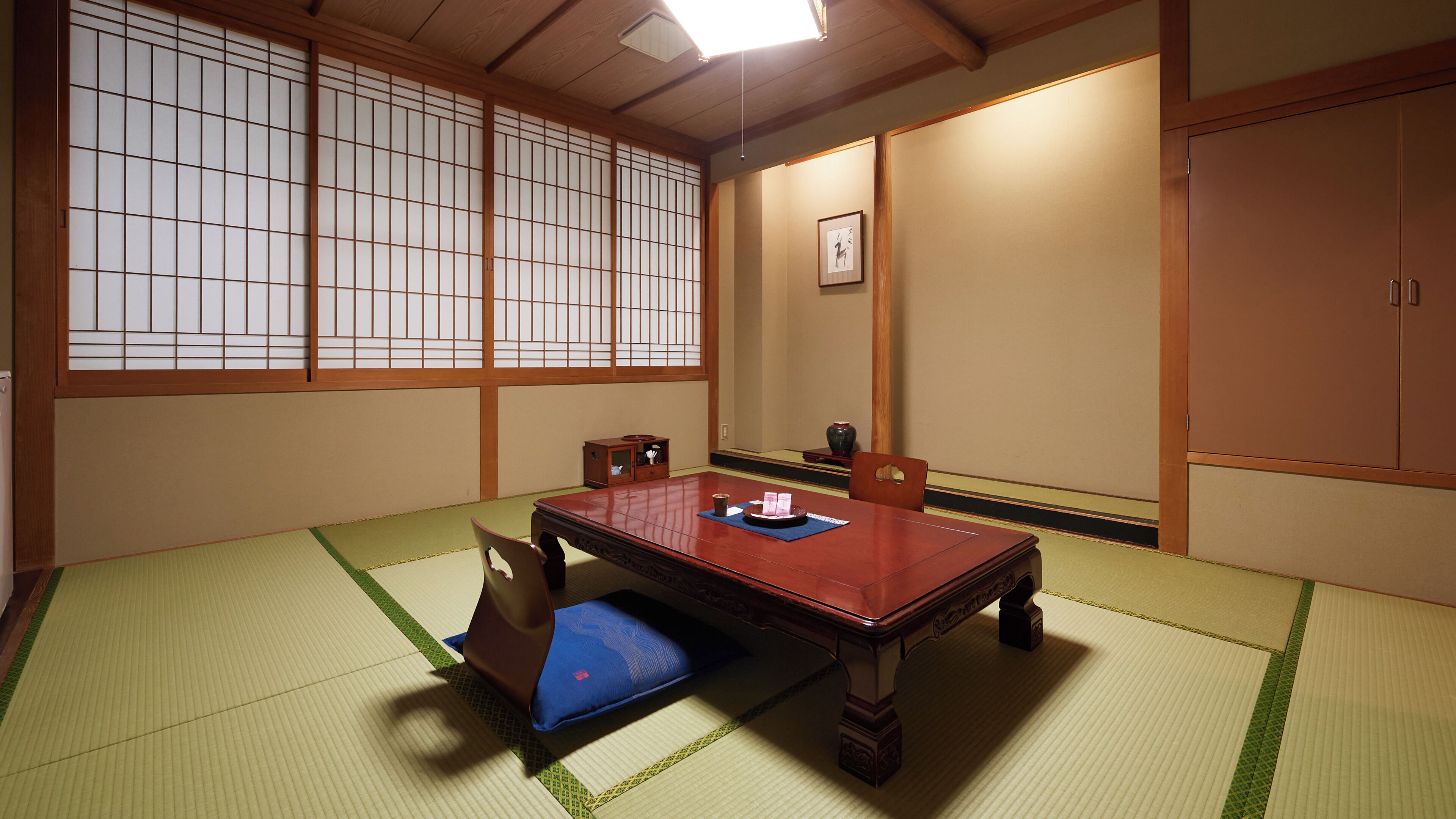 Een traditionele Japanse kamer met tatami matten, een lage tafel en schuifdeuren.