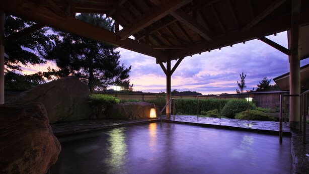 Una piscina coberta a l'aire lliure amb vistes al capvespre i al paisatge circumdant.