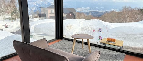 Una habitación con un ventanal que ofrece vistas a un paisaje nevado de montañas.