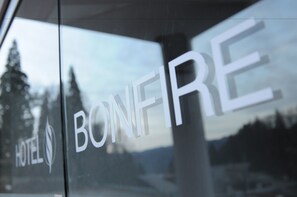 Une enseigne d’hôtel portant le nom « BONFIRE » et un logo comprenant une feuille.