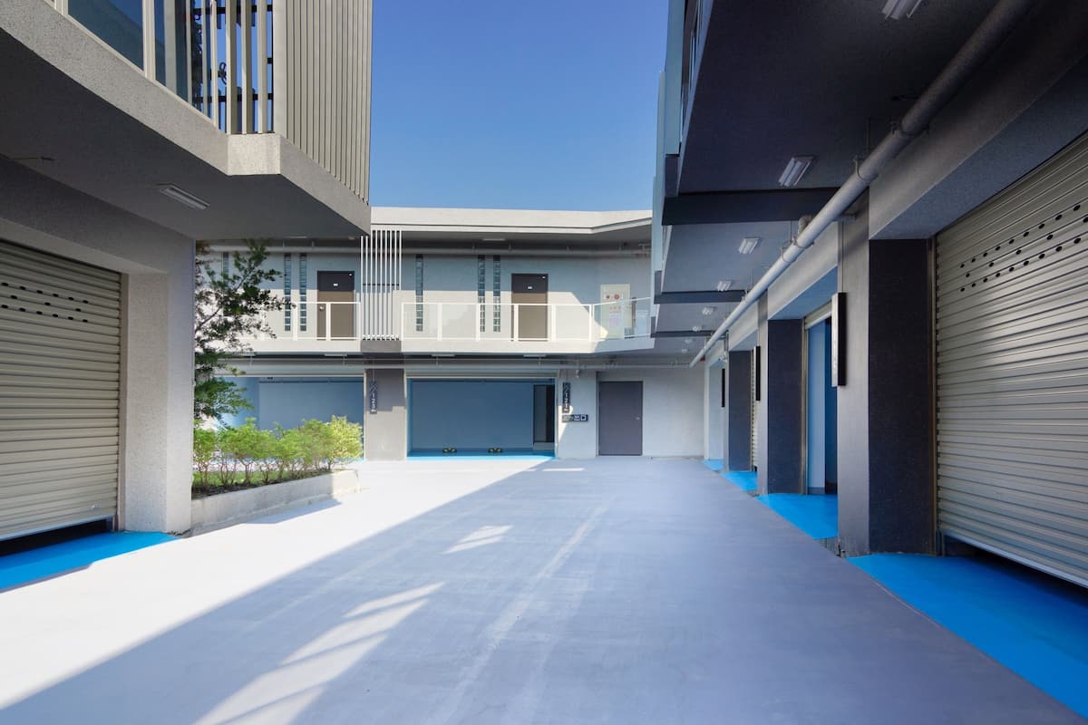 A modern building with a covered walkway and garage doors.