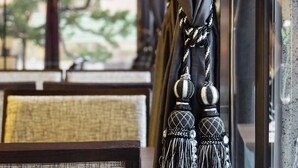 A window with dark curtains and a decorative tassel hanging from the curtain rod. - HOYA Resort Hotel Kaohsiung (Kaohsiung)