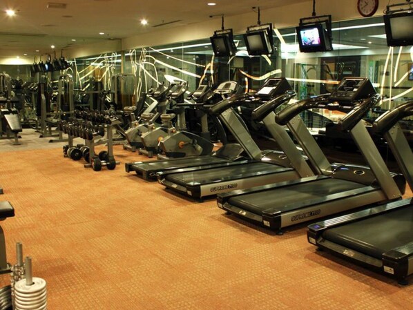 A gym with multiple treadmills, weight machines, and dumbbells. - Imperial Palace Hotel (Miri)
