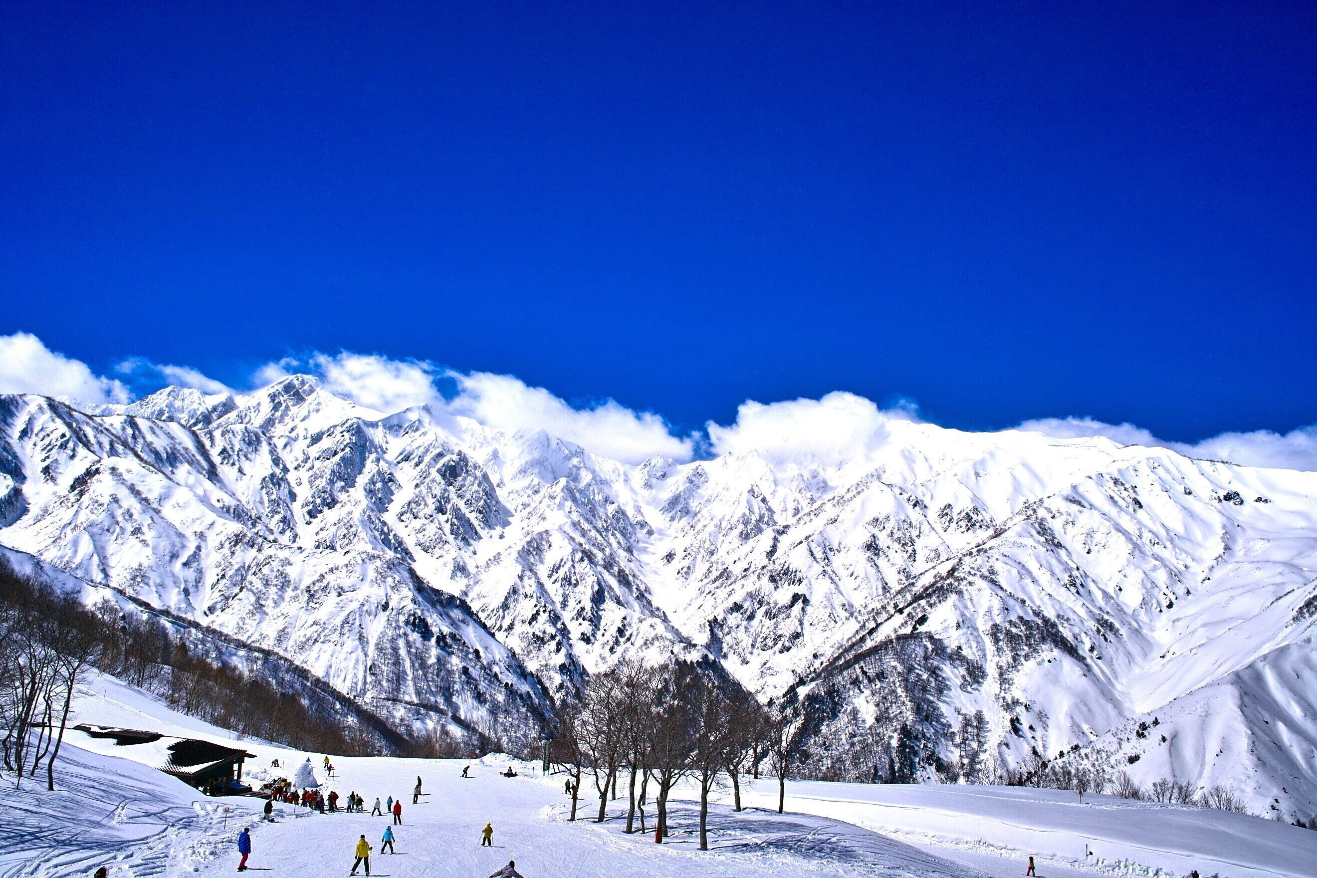 Eine verschneite Berglandschaft mit blauem Himmel.