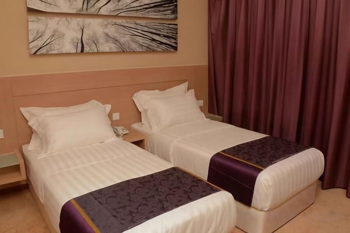 Two twin beds with headboards, a nightstand, and a telephone.