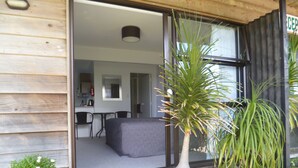 A modern wooden building with a visible kitchen area, a dining table, and a large potted plant. - Opua Boutique Seaview Motel (Opua)