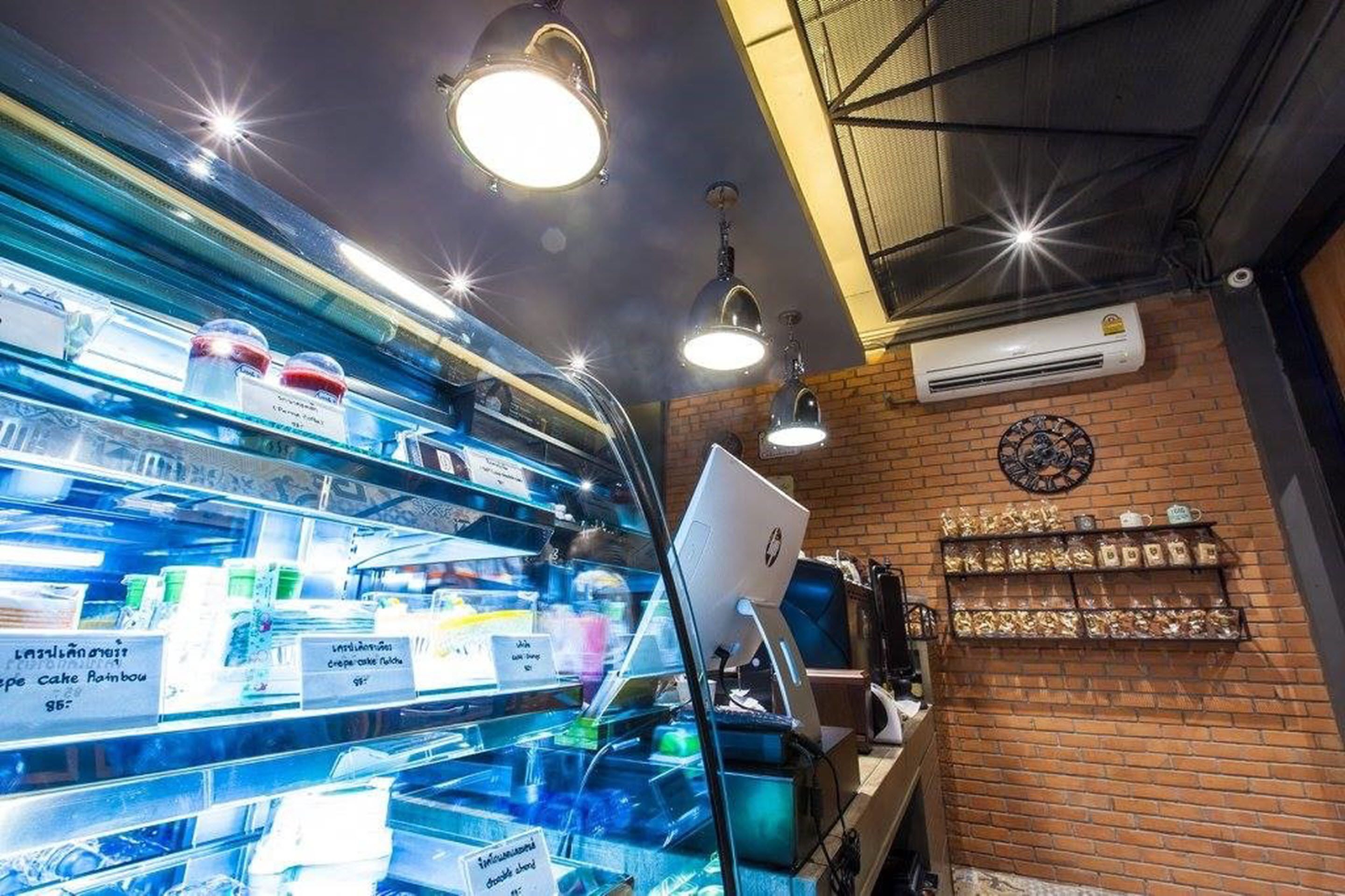 Una vitrina de panadería con diversos productos horneados y un monitor de computadora sobre un mostrador.