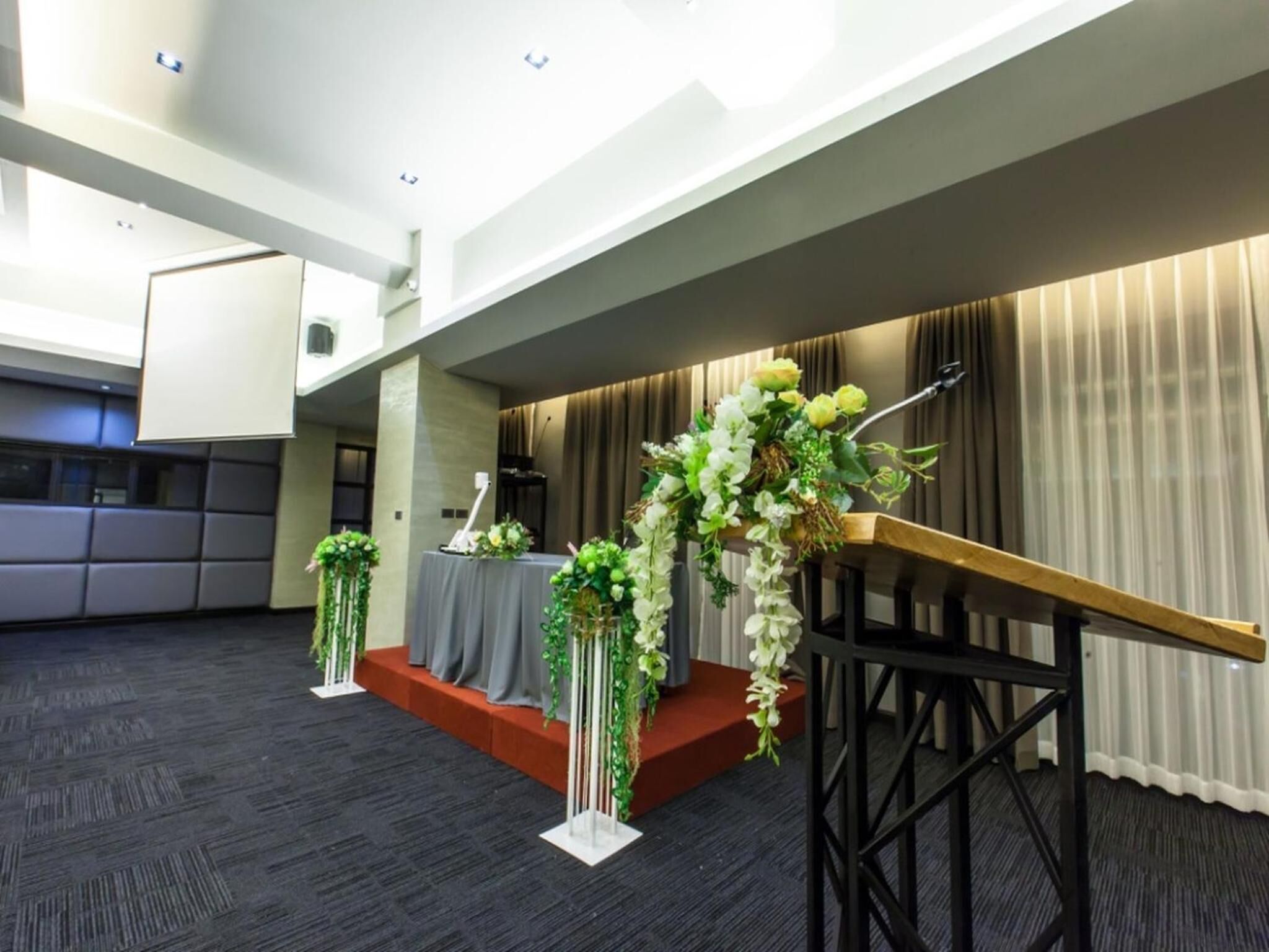 A modern conference room with a podium, a table with a microphone, and a backdrop.