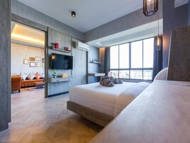 Una habitación de hotel moderna con una cama grande, una televisión, un sofá y una zona de comedor.