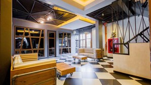 A modern interior with a checkered floor, wooden furniture, and large windows. - Loftmania Boutique Hotel (Chumphon)
