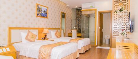 A twin room with two beds, a wooden desk, and a shower area.