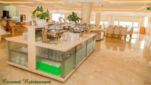 A modern restaurant with a central buffet area, seating arrangements, and large windows. - Palm Hotel Thanh Hoa (Hac Thanh)