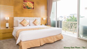 A luxury suite room with a large bed, a painting above the bed, and a balcony with a view. - Palm Hotel Thanh Hoa (Hac Thanh)