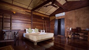 Ein Zimmer mit Holzboden, einem Bett, einem Schreibtisch und einem Stuhl.