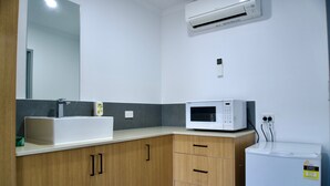 A modern bathroom with a white sink, a microwave, and a refrigerator. - Ararat Colonial Lodge Motel (Ararat)