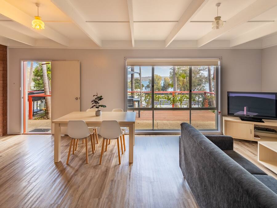 Una sala de estar moderna con comedor, ventanas amplias y televisor.