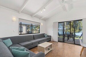 Deluxe Waterfront Cabin | Living area | Flat-screen TV