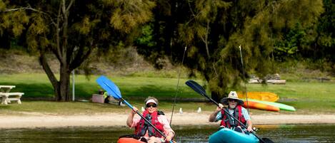Deux personnes pratiquent le kayak sur une rivière paisible.