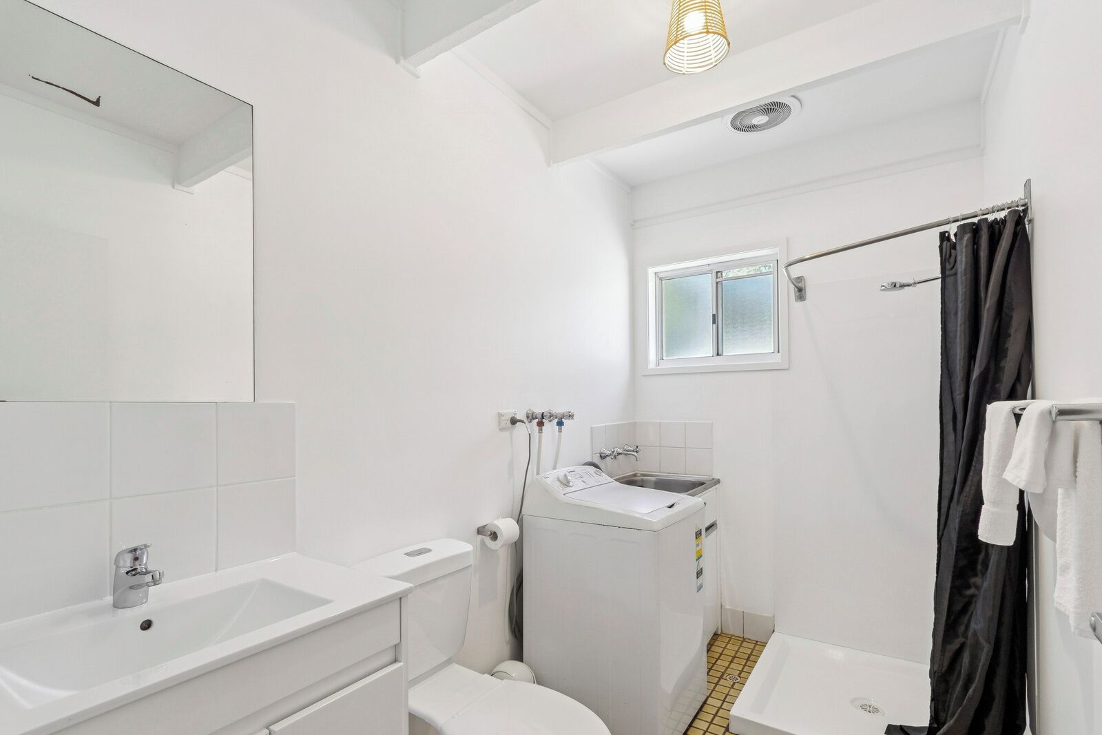 Uma casa de banho moderna com banheira, lavatório, sanita e zona de duche.