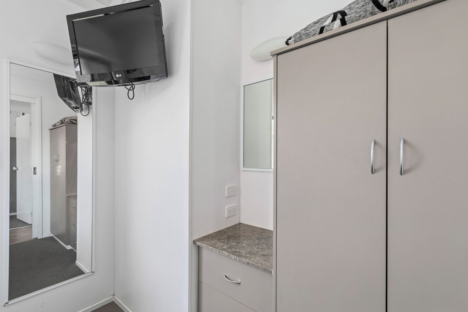 A bathroom with a mirror, a sink, and a toilet.