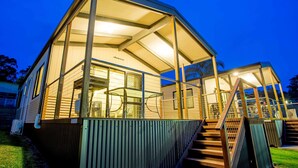A modern, glass-enclosed building with a metal staircase leading to a covered entrance. - Ingenia Holidays Bermagui (Wallaga Lake)