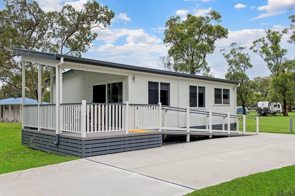 Une maison mobile de plain-pied dotée d’un porche couvert et d’une petite terrasse.